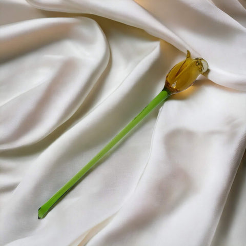 a single yellow flower on a white cloth