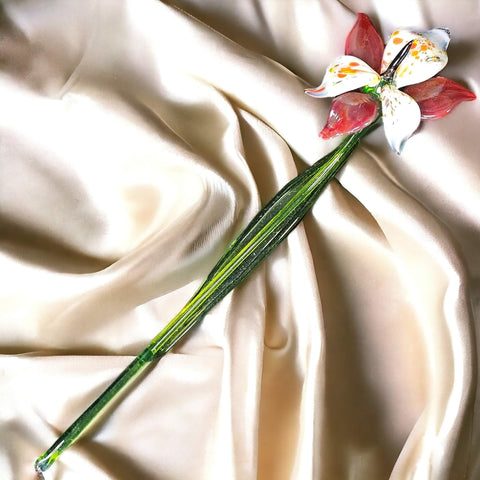 a flower on a stem on a satin surface