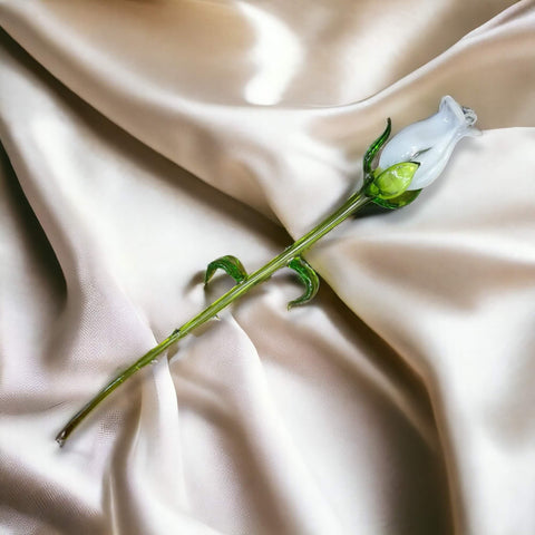 a single flower on a white satin fabric