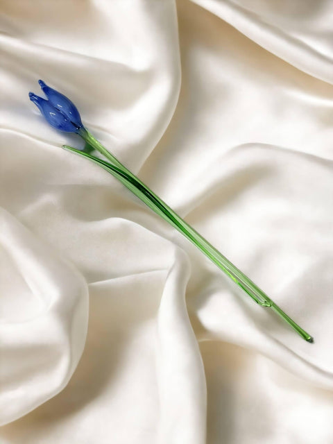 a single blue flower on a white satin