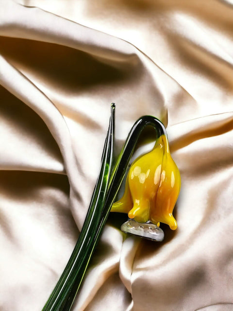 a yellow flower sitting on top of a white cloth