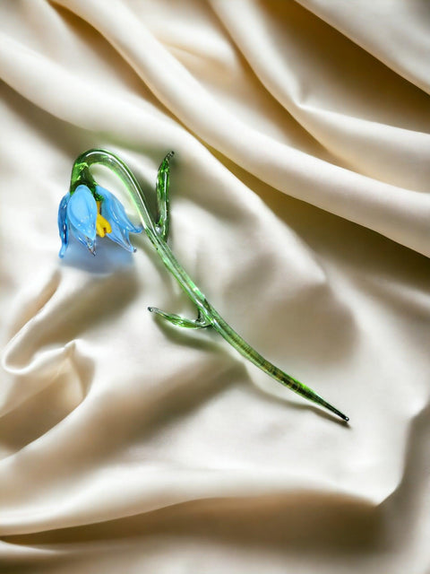 a blue flower sitting on top of a white sheet