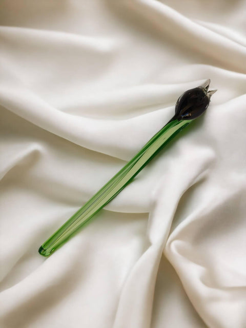 a black flower is laying on a white sheet