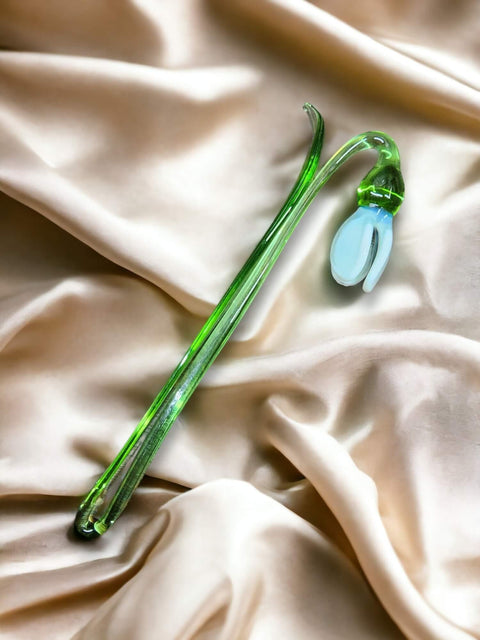 a green flower laying on top of a white cloth