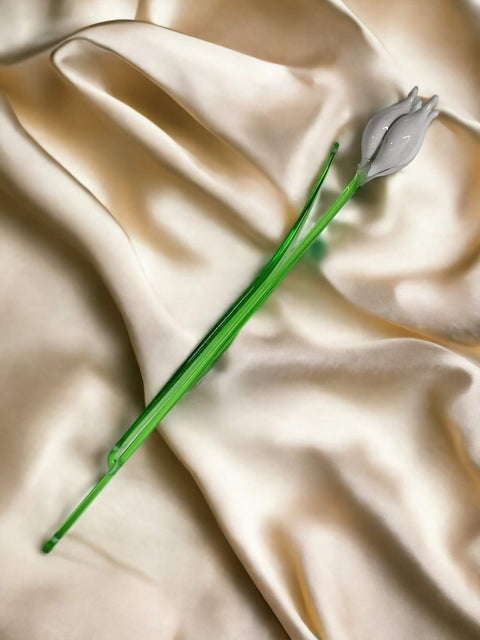 a flower laying on top of a white cloth