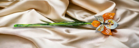 a flower on a white cloth with a green stem