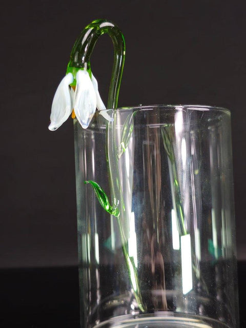 a glass vase with a flower in it