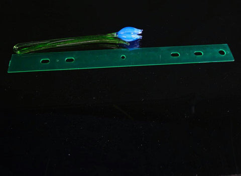 a blue flower sitting on top of a green piece of plastic