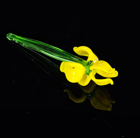 a yellow flower is sitting on a black surface