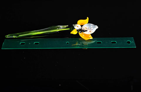 a yellow flower sitting on top of a green piece of plastic