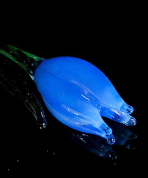 a blue glass object sitting on top of a black surface