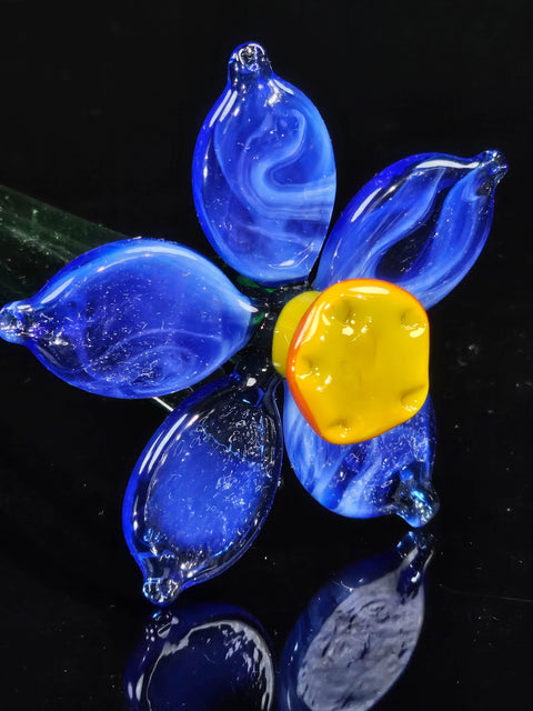 a blue glass flower with yellow and orange petals