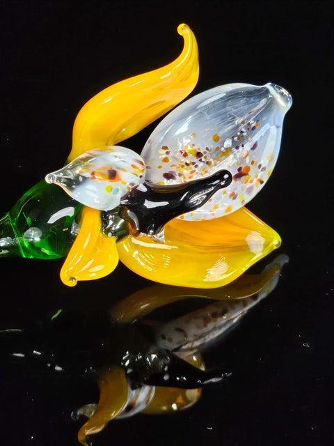 a glass sculpture of a flower on a black surface