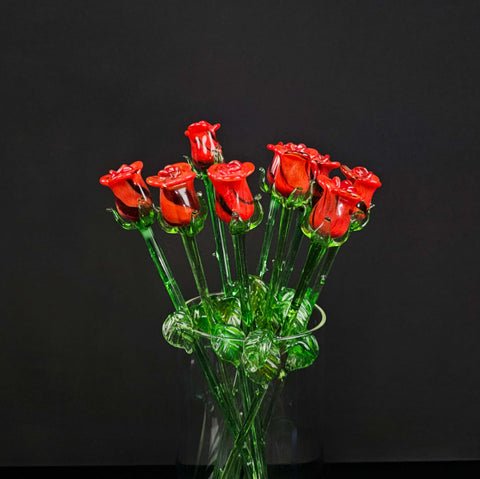 a glass vase filled with red roses on a table