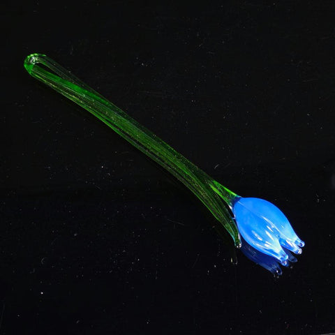 a blue flower with green stems on a black surface