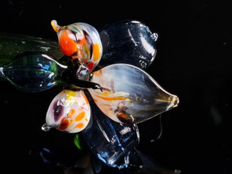 a flower made of glass sitting on top of a table