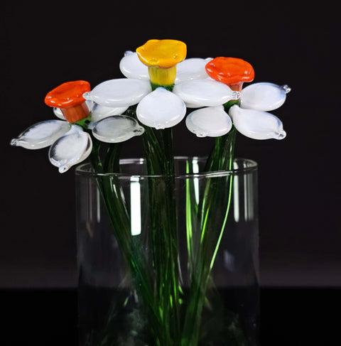 a glass vase filled with white and orange flowers