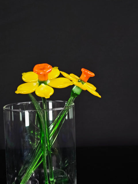 a glass vase filled with yellow and orange flowers