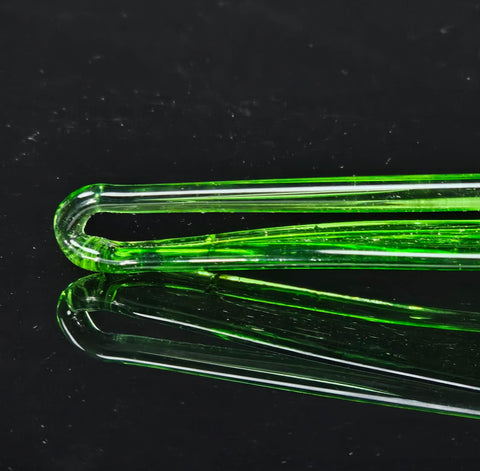 a close up of a green glass object on a black surface