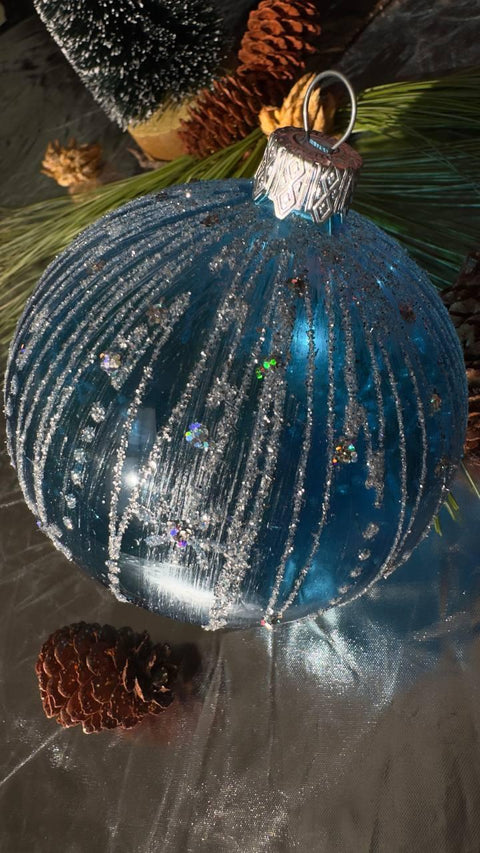 a blue christmas ornament sitting on top of a table