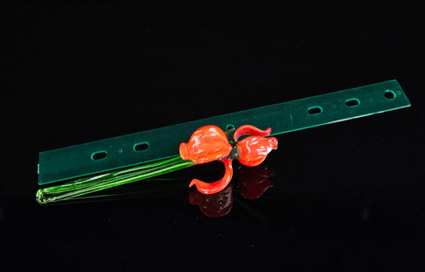 a piece of green plastic with red flowers on it