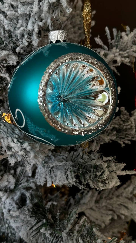 a blue ornament hanging from a christmas tree