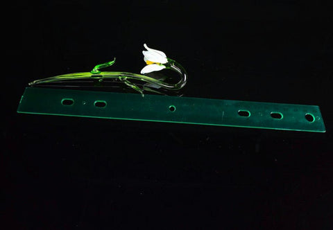 a white flower sitting on top of a green piece of plastic