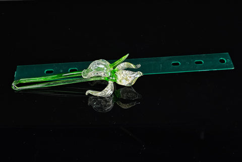 a green piece of glass sitting on top of a black surface